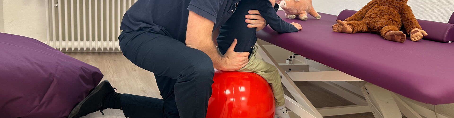 Dmitrij Rohovoy mit Kind auf Gymnastikball